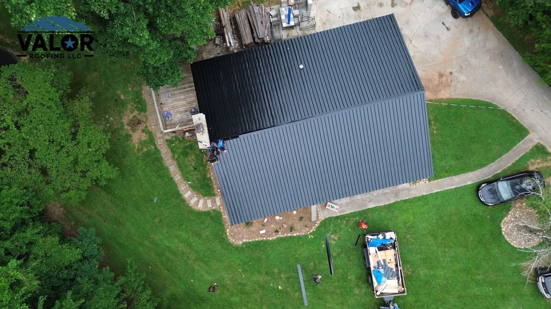 Drone view of a Valor Roofing crew installing a standing-seam metal roof